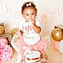baby, toddler, cake, birthday, pink_tutu, white_shirt, cake_smash, frosting, party_decor, balloons, pink_bow, smiling, celebration, child, cute, sitting, cake_stand, indoor, happy, person