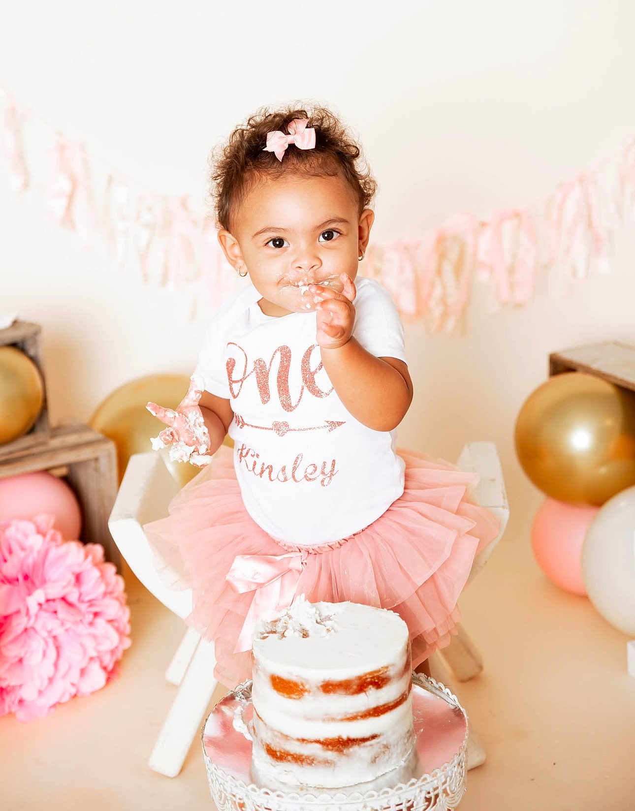 Kinsley Grace Morris is registered to the contest to win money with this photo: baby, toddler, cake, birthday, pink_tutu, white_shirt, cake_smash, frosting, party_decor, balloons, pink_bow, smiling, celebration, child, cute, sitting, cake_stand, indoor, happy, person