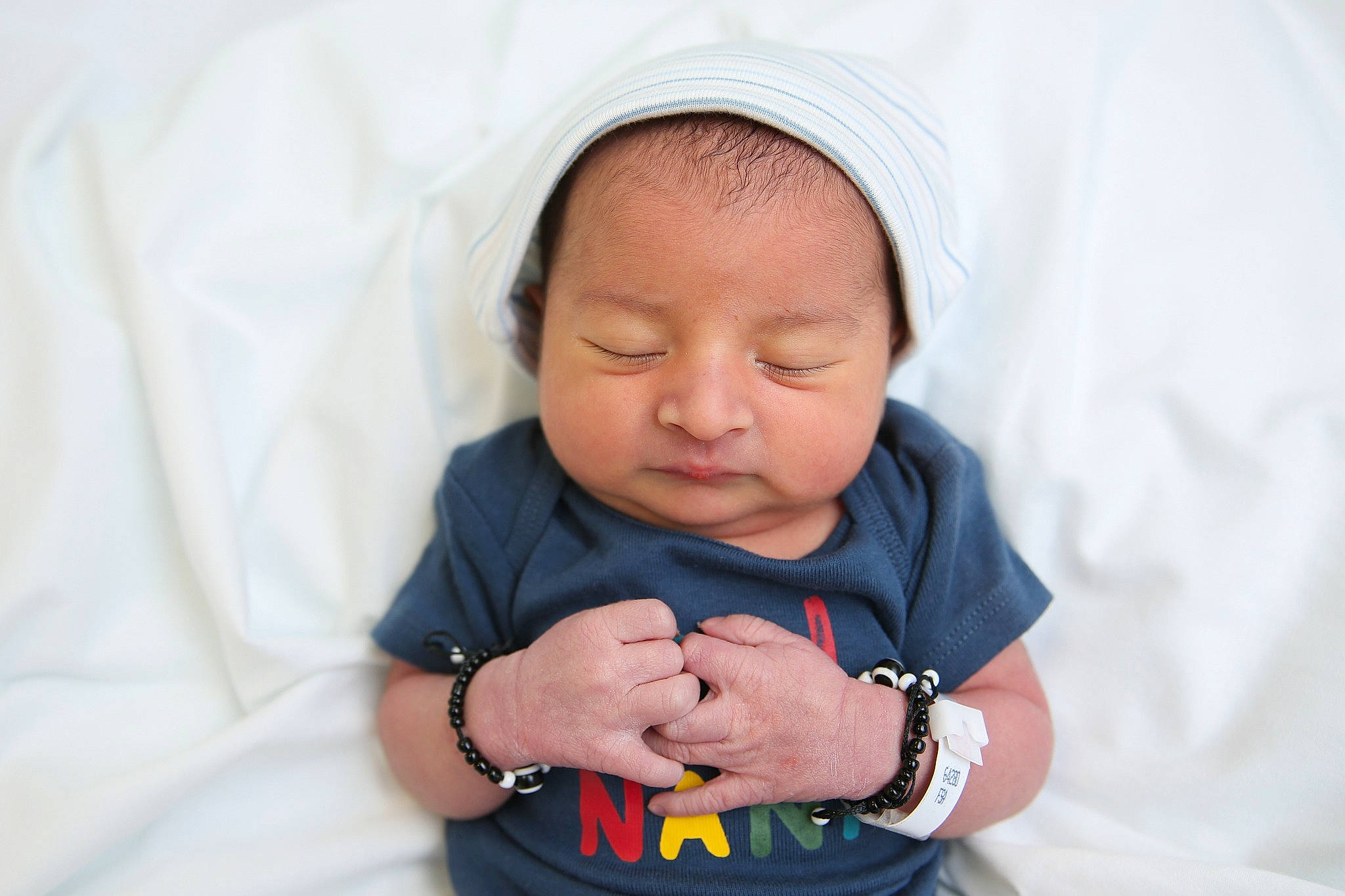 Ibrahim is registered to the contest to win money with this photo: arm, baby, baby_toddler_clothing, cheek, comfort, dress, eye, face, facial_expression, finger, gesture, hand, happy, mouth, nose, person, skin, sleeve, smile, textile