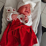 Sarah participe au concours pour gagner de l'argent avec cette photo : baby, infant, smiling, red_dress, white_headband, bow, blanket, lying_down, happy, cute, indoors, tights, white_tights, soft_texture, chubby_cheeks, closed_eyes, festive, cozy, child, portrait