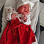 baby, infant, smiling, red_dress, white_headband, bow, blanket, lying_down, happy, cute, indoors, tights, white_tights, soft_texture, chubby_cheeks, closed_eyes, festive, cozy, child, portrait