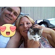 Ember Jayne Basdon joined the competition — help win amazing prizes! couple, man, woman, cat, selfie, smiling, outdoor, fence, holding, emoji, heart_eyes, face, pet, casual, portrait, timestamp, phone_interface, happy, people, animal