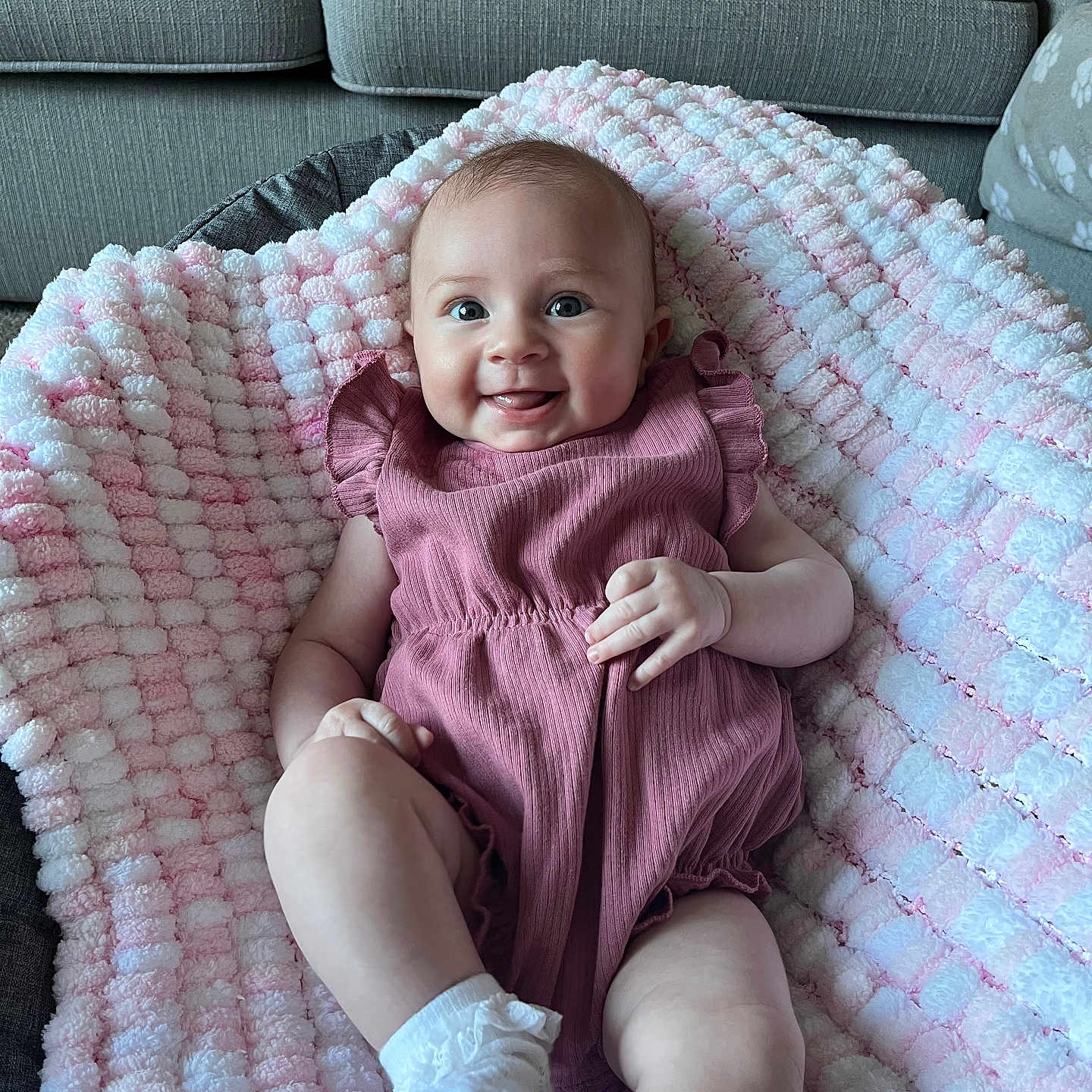 Gracie is registered to the contest to win money with this photo: baby, blanket, clothing, couch, cushion, dress, face, furniture, happy, head, homedecor, hosiery, pants, person, photography, portrait, quilt, sitting, smile, sock