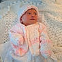 Jessie-June is registered to the contest to win money with this photo: newborn, baby, knitted_hat, knitted_mittens, knitted_sweater, blanket, crochet, white, pink, infant, soft_texture, sleepwear, cute, small, portrait, laying_down, indoors, child, warm_clothing, peaceful