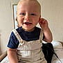 Isaac a rejoint le concours — aidez-le/la à gagner de superbes lots ! child, toddler, smiling, overalls, toy_car, blue_eyes, short_hair, sitting, indoor, cushion, patterned, navy_shirt, beige_clothing, happy, face, hand, person, playful, cute, portrait
