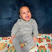 Demuir joined the competition — help win amazing prizes! baby, child, smiling, gray_onesie, blanket, holiday_theme, gingerbread_house, candy_cane, sitting, happy, cute, indoor, portrait, cozy, infant, plush, colorful, clothing, face, joyful