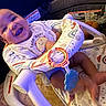 Zymir is registered to the contest to win money with this photo: baby, smiling, infant, baby_seat, toy, happy, indoor, clothing, child, face, person, seat, colorful, pattern, playful, cute, young, sitting, joyful, comfort