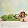 baby, infant, pea_pod_costume, knitted, green, pillow, pink, hair_ties, colorful, wooden_blocks, month_marker, milestone, cute, lying_down, soft_rug, portrait, studio, child, newborn, face