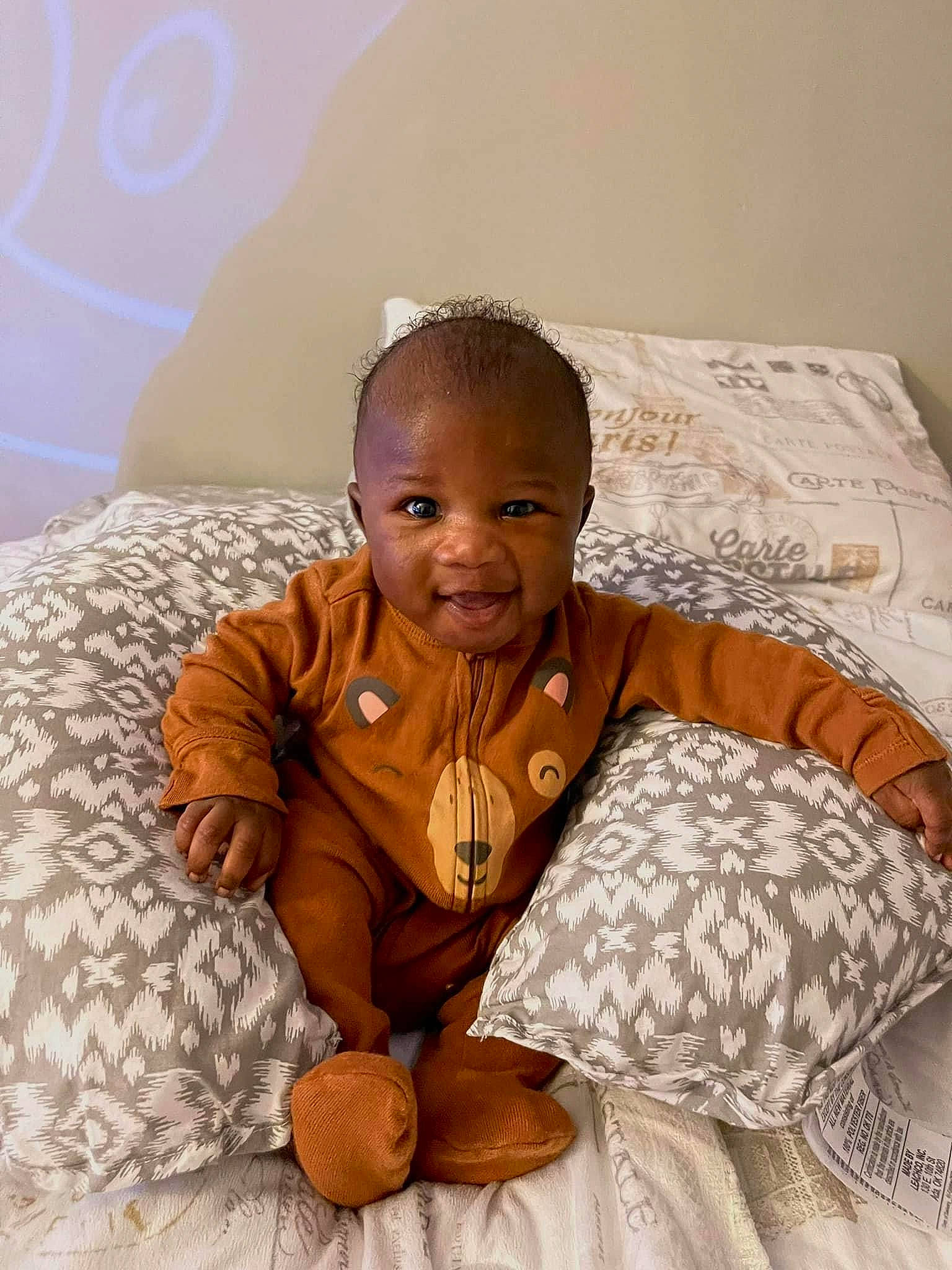Zaiden is registered to the contest to win money with this photo: abdomen, baby, ball, child, comfort, face, facial_expression, fun, happy, human_body, laugh, linens, person, room, sitting, skin, sleeve, smile, t_shirt, toddler