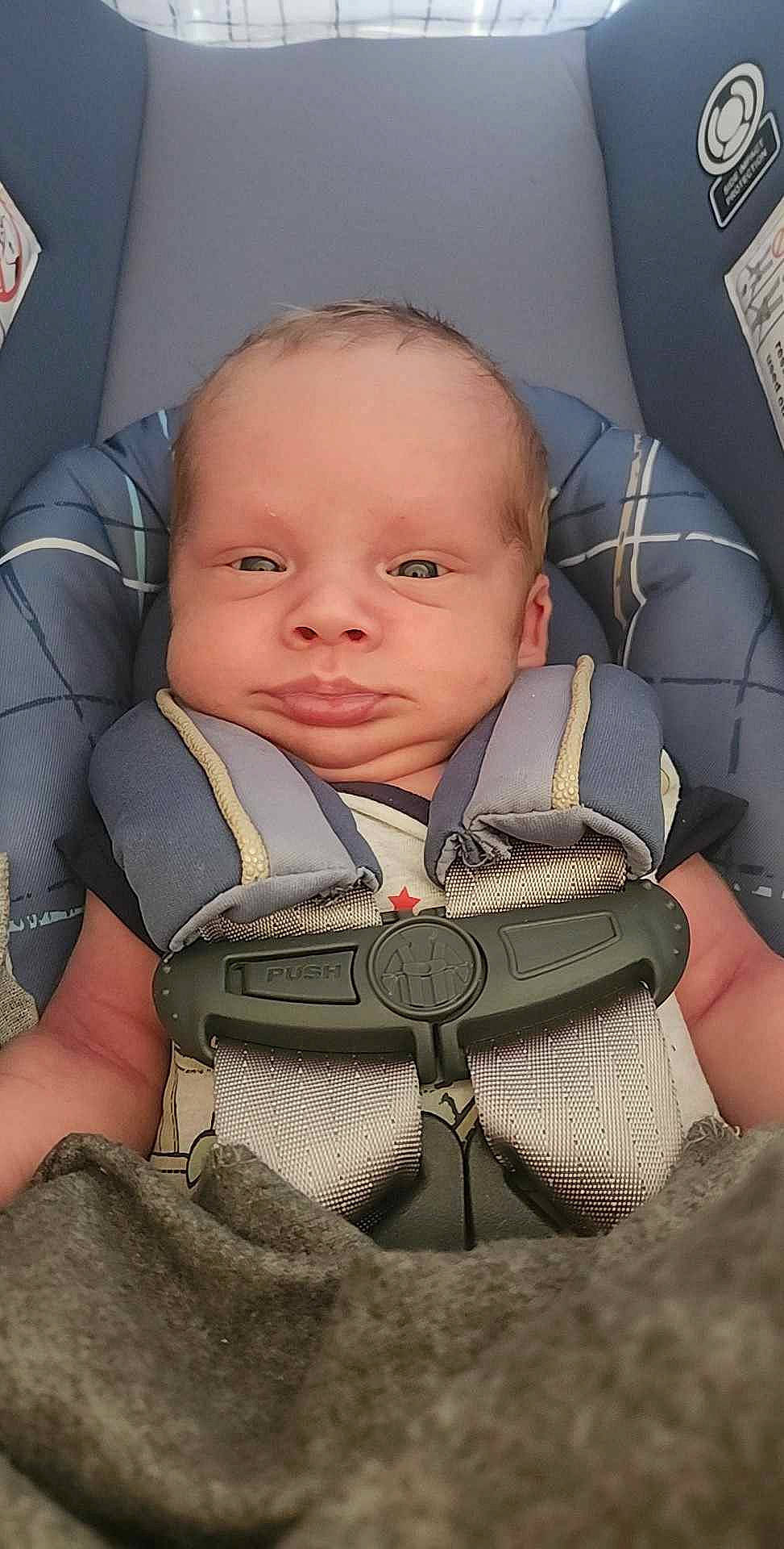 Kylo is registered to the contest to win money with this photo: auto_part, baby, baby_carriage, baby_in_car_seat, baby_products, baby_safety, baby_toddler_clothing, car_seat, cheek, child, comfort, head_restraint, person, personal_protective_equipment, seat_belt, sitting, skin, smile, thumb, toddler