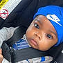 Jakory joined the competition — help win amazing prizes! baby, infant, child, car_seat, seat_belt, blue_hat, nike, clothing, face, eyes, hands, black_strap, gray_shirt, safety, portrait, cute, indoors, warning_label, closeup, seat
