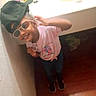 Nevaeh is registered to the contest to win money with this photo: bathroom, cap, casual_clothing, child, counter, floor, happy, indoor, jeans, person, pink_shirt, playful, portrait, sink, smile, sneakers, standing, sunglasses, wall, young