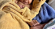 Sariah joined the competition — help win amazing prizes! baby, towel, blanket, face, infant, child, cute, smile, skin, head, comfort, soft, fabric, animal_hood, lotion, bottle, lying_down, cozy, warm, indoors