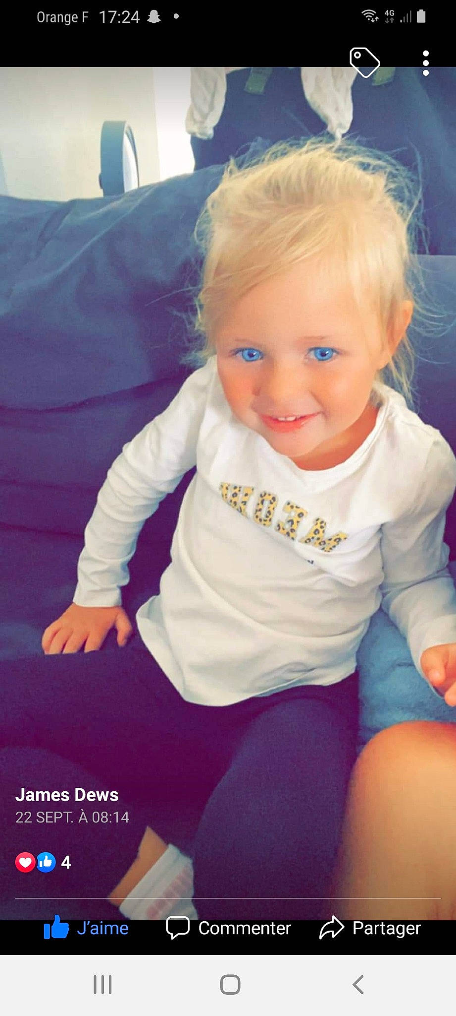 Chelsea participe au concours pour gagner de l'argent avec cette photo : baby, baby_toddler_clothing, blond, cheek, electric_blue, eye, finger, gesture, hair, happy, head, human_body, iris, joy, person, sitting, sleeve, smile, t_shirt, thigh