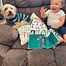 baby, dog, couch, pillow, striped_sweater, brown_couch, happy, child, pet, indoor, holiday, festive, candy_cane, cloth, smiling, cute, cozy, sitting, fur, playful