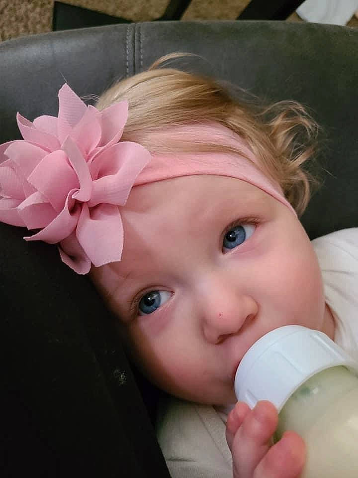 Karlie is registered to the contest to win money with this photo: baby, baby_bottle, baby_toddler_clothing, beauty, cheek, drinkware, ear, eyelash, finger, hand, headpiece, headwear, lip, nail, nose, person, pink, plant_milk, plastic_bottle, product