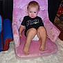Grayson is registered to the contest to win money with this photo: toddler, child, pink_chair, black_shirt, nike_logo, diaper, carpet, blanket, indoor, foot, face, person, furniture, plush, expression, hair, toy_car, floor, home, seated
