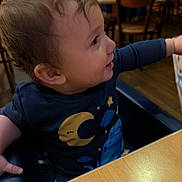 Blaize joined the competition — help win amazing prizes! toddler, child, baby, blue_clothing, high_chair, indoor, restaurant, wooden_chairs, table, curly_hair, profile_view, cute, smiling, reaching, face, person, young_child, casual_wear, seated, happy