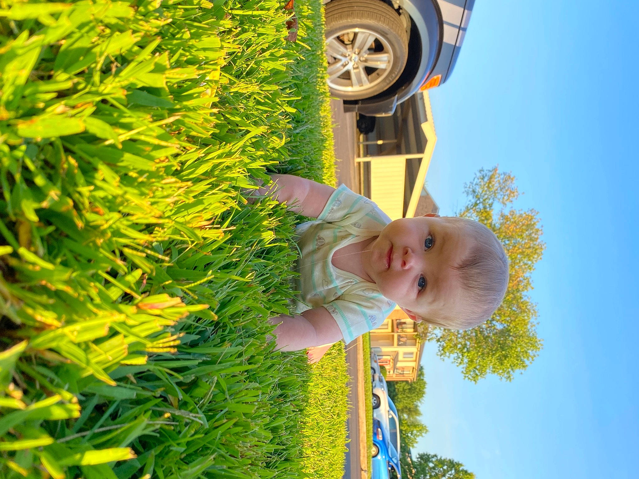 Paxton joined the competition — help win amazing prizes! automotive_tire, baby, car, face, grass, happy, hubcap, leaf, light, motor_vehicle, people_in_nature, person, plant, sky, smile, tire, toddler, tree, vehicle, wheel