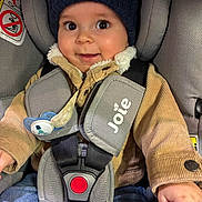 Louis participe au concours pour gagner de l'argent avec cette photo : baby, blue_jeans, car_seat, child, closeup, corduroy_jacket, cute, expression, face, hat, indoors, infant, knit_hat, pacifier, safety, seatbelt, smiling, straps, toddler, warm_clothing