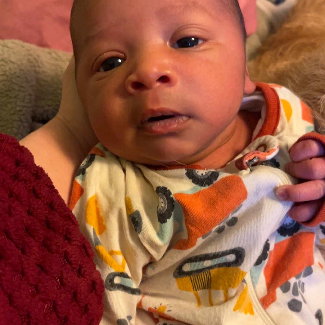 Zayden is registered to the contest to win money with this photo: baby, bed, bedroom, blanket, clothing, coat, couch, cushion, face, furniture, glove, hat, head, homedecor, indoors, newborn, person, photography, portrait, quilt