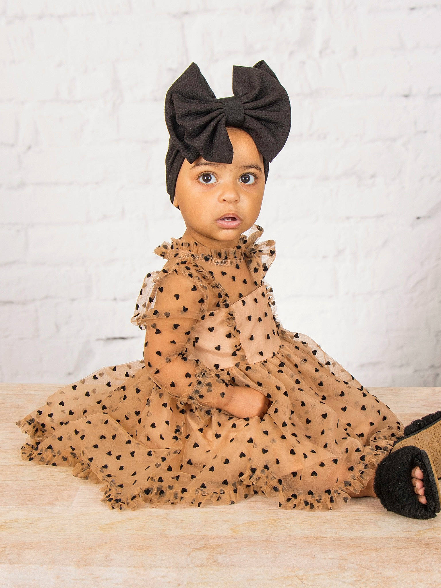 Karma is registered to the contest to win money with this photo: cap, costume, costume_hat, day_dress, doll, fashion_accessory, fashion_design, figurine, flooring, font, fur, hat, headwear, neck, one_piece_garment, pattern, person, sitting, sleeve, toy
