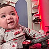 Grayson joined the competition — help win amazing prizes! baby, child, smile, toy_car, clothing, fire_truck, helicopter, face, eyes, indoor, sitting, joyful, expression, shelf, toy, red_light, playful, cute, infant, person