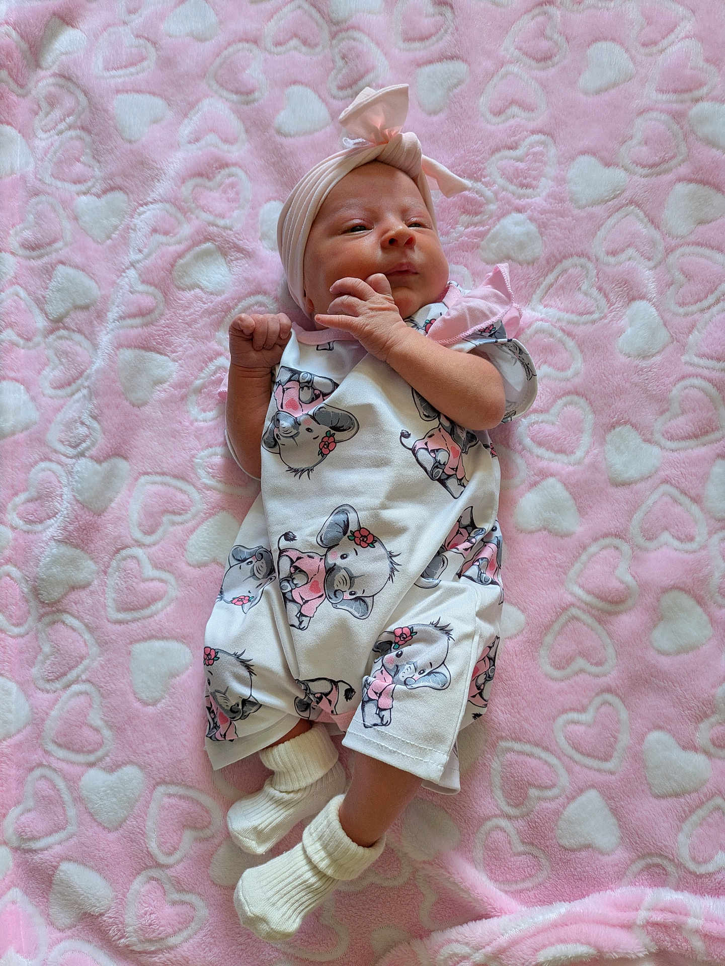 Willow is registered to the contest to win money with this photo: baby, infant, blanket, pink, hearts, headband, socks, clothing, cute, lying_down, soft, pattern, animal_print, koala, fabric, newborn, child, portrait, indoors, resting