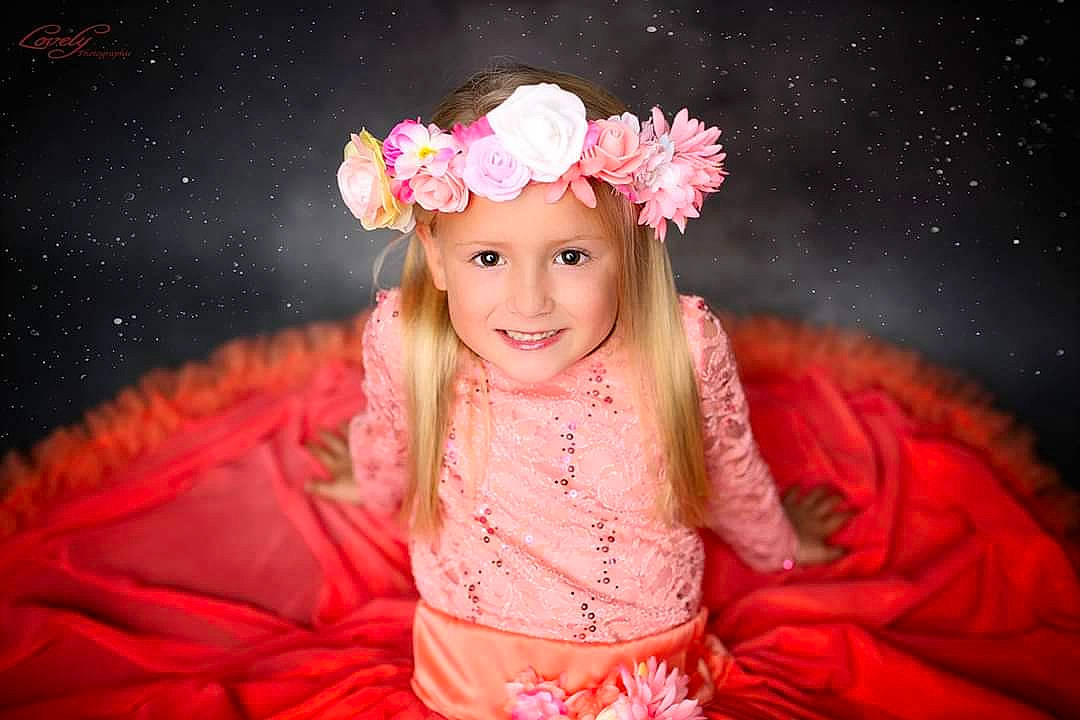 Caly a rejoint le concours — aidez-le/la à gagner de superbes lots ! beauty, child, costume, flower, fun, girl, hair_accessory, happiness, headpiece, infant, joy, person, petal, pink, portrait, portrait_photography, red, rose_family, skin, smile