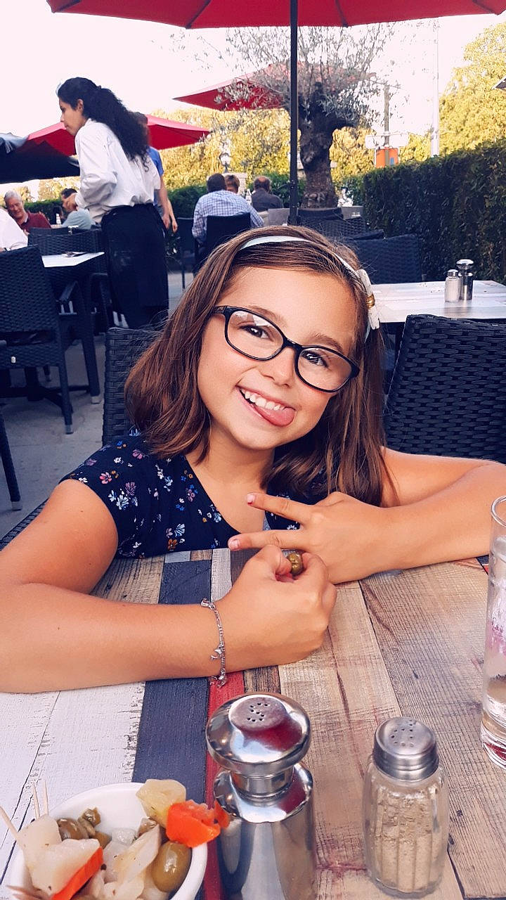 Louna a rejoint le concours — aidez-le/la à gagner de superbes lots ! bottle, chair, dress, drinking_water, drinkware, glasses, home_accessories, joy, meal, outdoor_table, person, plastic_bottle, restaurant, salt_and_pepper_shakers, serveware, umbrella, vision_care, water_bottle