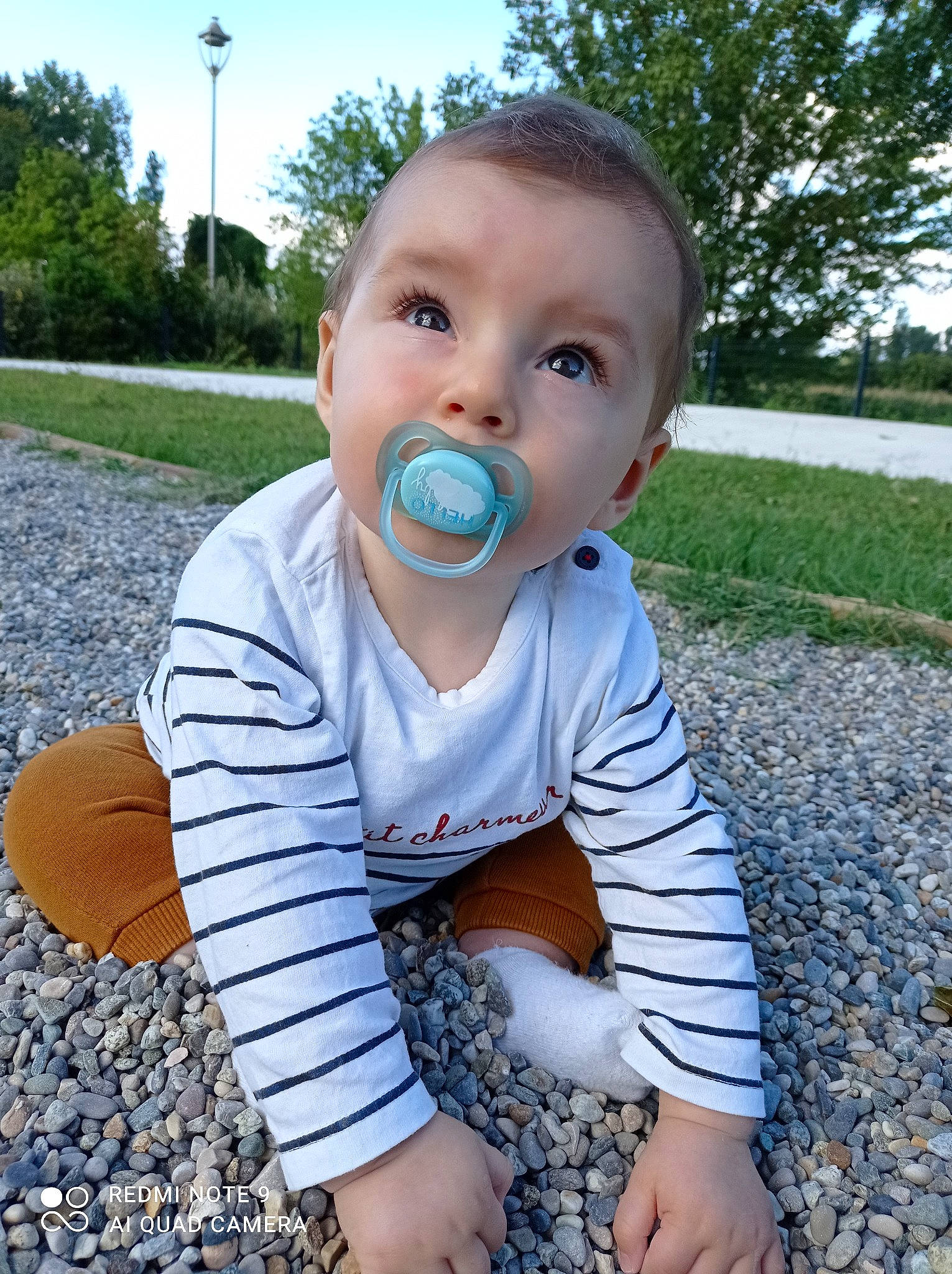 Tilio participe au concours pour gagner de l'argent avec cette photo : baby, baby_toddler_clothing, child, electric_blue, face, grass, happy, leaf, pattern, people_in_nature, person, plant, sitting, sky, sleeve, spring, standing, summer, t_shirt, toddler