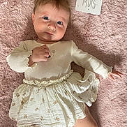 Amélia a rejoint le concours — aidez-le/la à gagner de superbes lots ! baby, infant, child, cute, white_clothing, skirt, lying_down, pink_blanket, soft_texture, milestone_card, face, eyes, hand, foot, expression, indoor, portrait, newborn, young_child, sleepwear