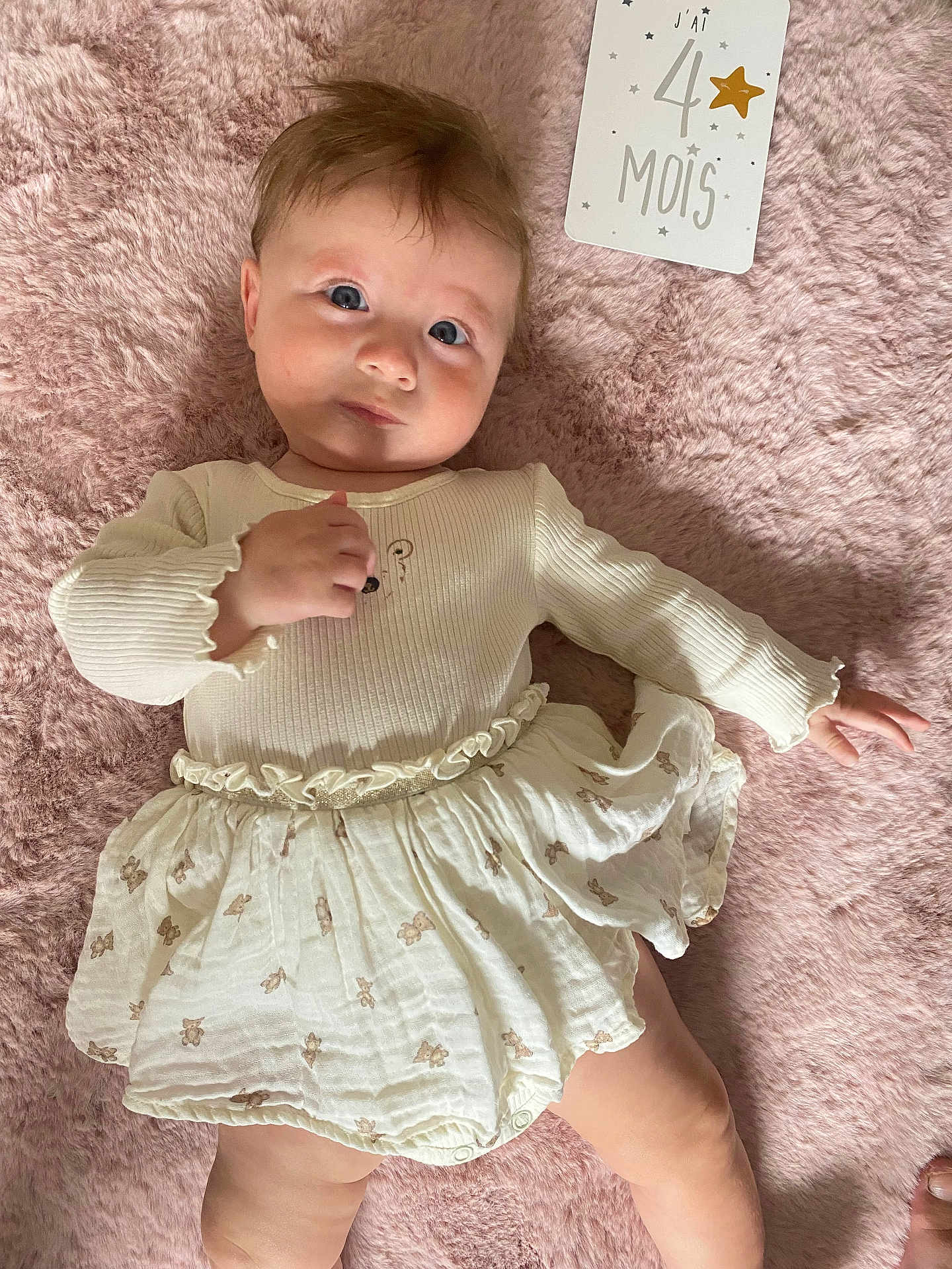 Amélia a rejoint le concours — aidez-le/la à gagner de superbes lots ! baby, infant, child, cute, white_clothing, skirt, lying_down, pink_blanket, soft_texture, milestone_card, face, eyes, hand, foot, expression, indoor, portrait, newborn, young_child, sleepwear