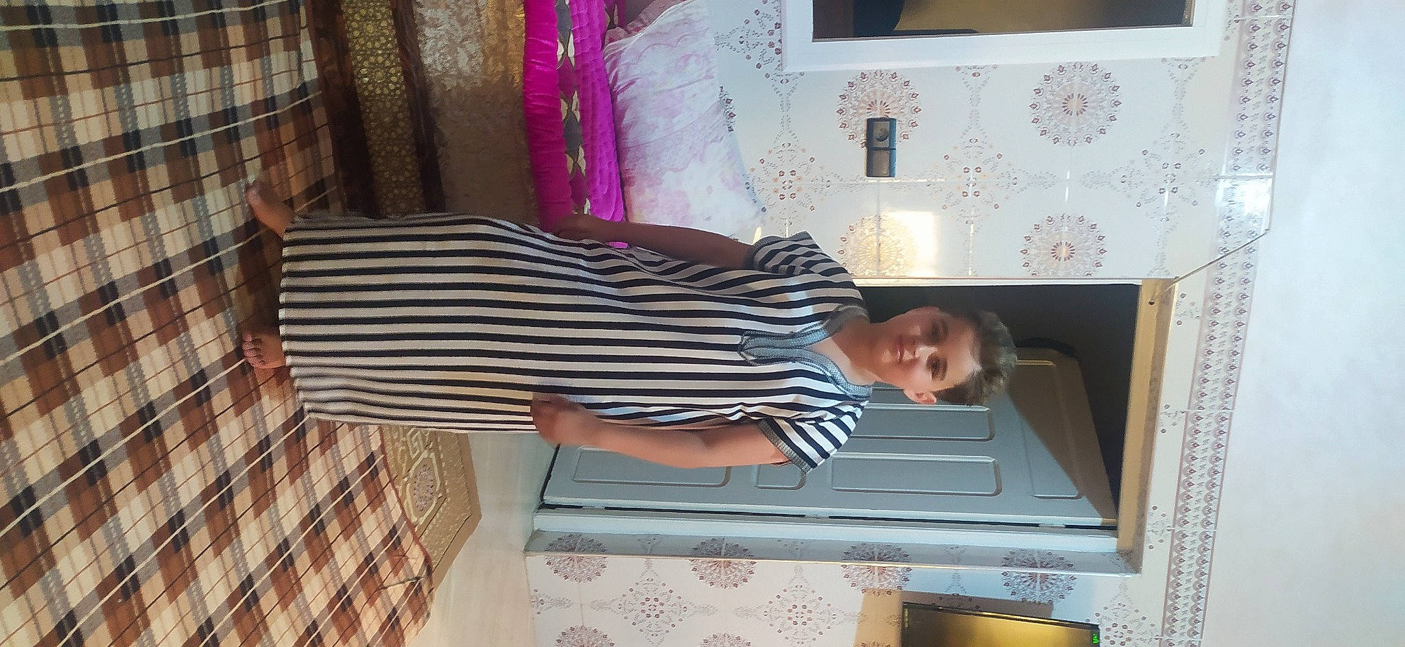 Bilal a rejoint le concours — aidez-le/la à gagner de superbes lots ! cabinetry, child, comfort, countertop, dress, flooring, hardwood, home_appliance, joy, kitchen, linens, magenta, pattern, person, plaid, purple, room, sleeve, t_shirt, tartan