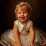Eva a rejoint le concours — aidez-le/la à gagner de superbes lots ! toddler, child, smiling, dress, crown, pearl, flower, tulle, sitting, barefoot, portrait, studio, happy, cute, girl, hands, feet, brown_background, innocent, celebration