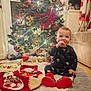 Kaloyan is registered to the contest to win money with this photo: baby, christmas_tree, christmas_stockings, holiday_decorations, festive_pajamas, smiling_child, cozy_rug, indoor, holiday_spirit, red_and_gold, ornaments, twinkling_lights, sitting, cute, child, festive, happy, celebration, winter, home