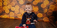 Kaloyan joined the competition — help win amazing prizes! baby, background, blue_pants, bokeh, child, christmas, cute, festive, happy, holiday, indoors, lights, long_sleeve, portrait, red_shoes, reindeer_sweater, sitting, smiling, wooden_floor, young