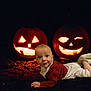 Kaloyan joined the competition — help win amazing prizes! baby, infant, jack_o_lantern, pumpkin, halloween, glow, night, darkness, costume, outdoor, face, smile, cute, child, orange, light, holiday, festive, lying_down, curious