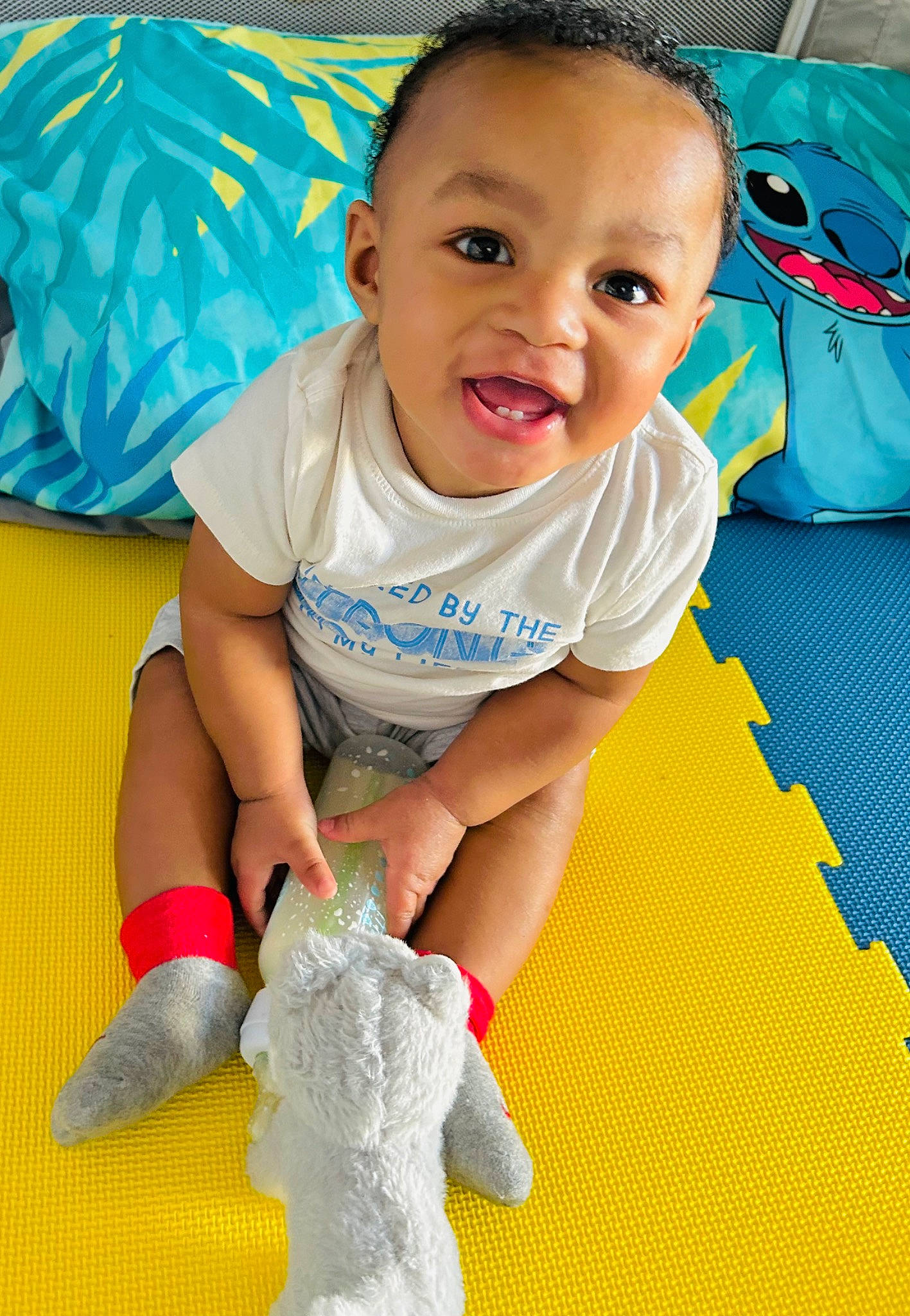 Angelo is registered to the contest to win money with this photo: baby, baby_toddler_clothing, child, electric_blue, finger, flooring, fun, gesture, happy, human_leg, leisure, person, play, sitting, skin, sleeve, smile, t_shirt, textile, thumb
