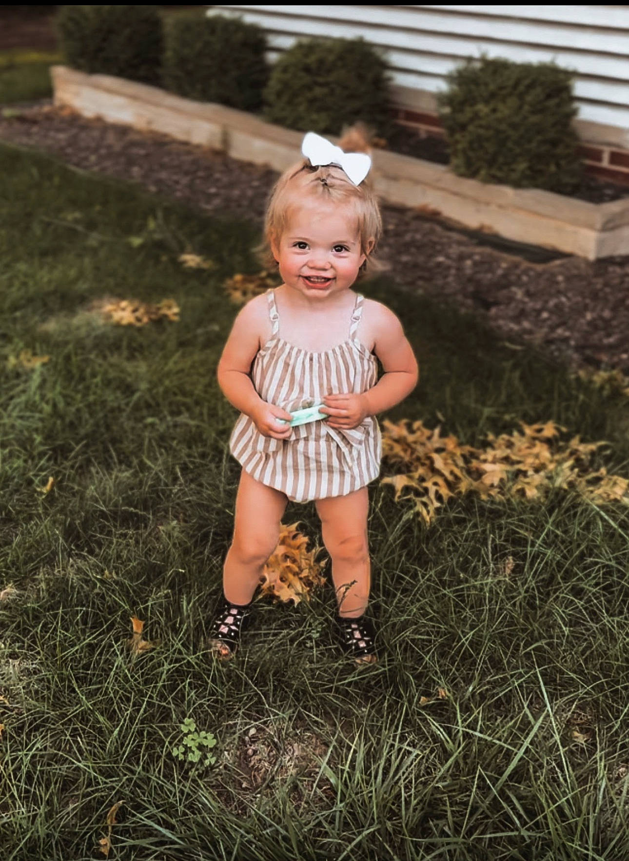 Stella is registered to the contest to win money with this photo: baby, baby_toddler_clothing, child, dress, face, flash_photography, fun, grass, grassland, happy, human_leg, joy, lawn, meadow, people_in_nature, person, plant, shorts, skin, standing