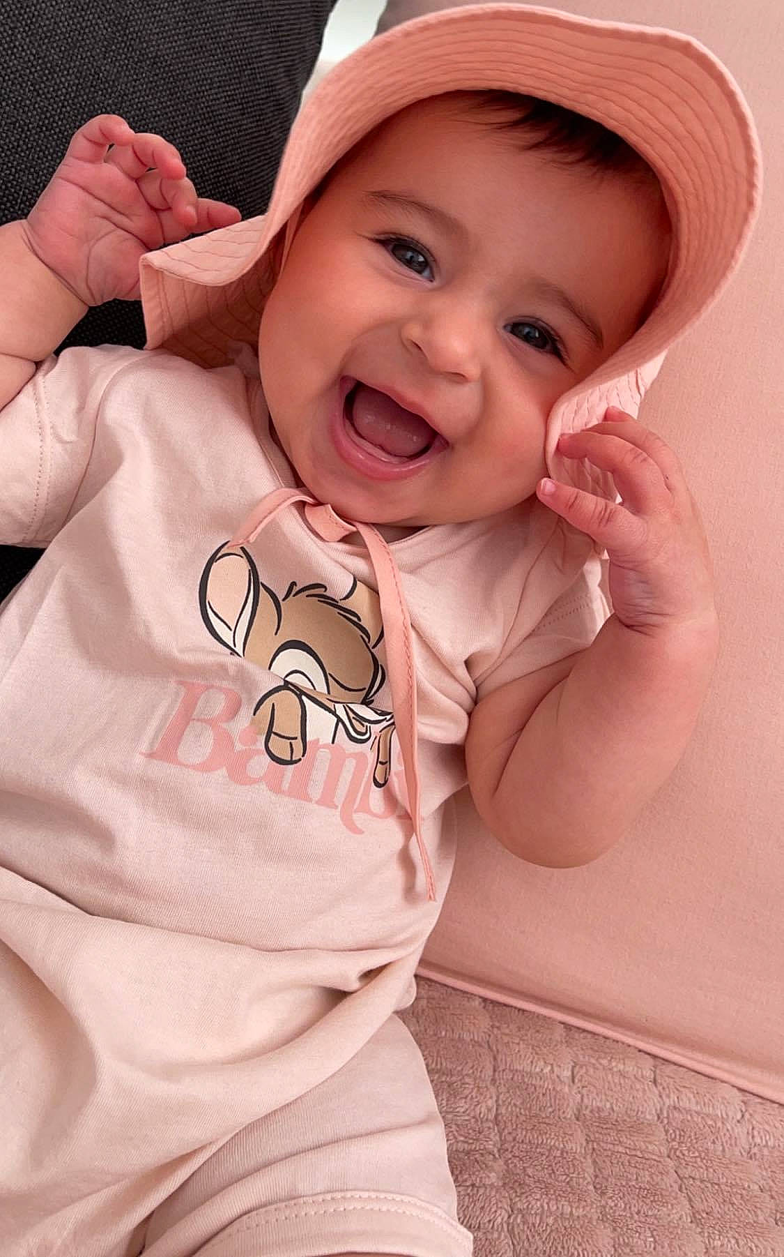 Eva participe au concours pour gagner de l'argent avec cette photo : baby, baby_products, baby_toddler_clothing, cap, cheek, child, chin, finger, gesture, happy, headgear, lip, mouth, nose, person, pink, skin, sleeve, smile, thumb
