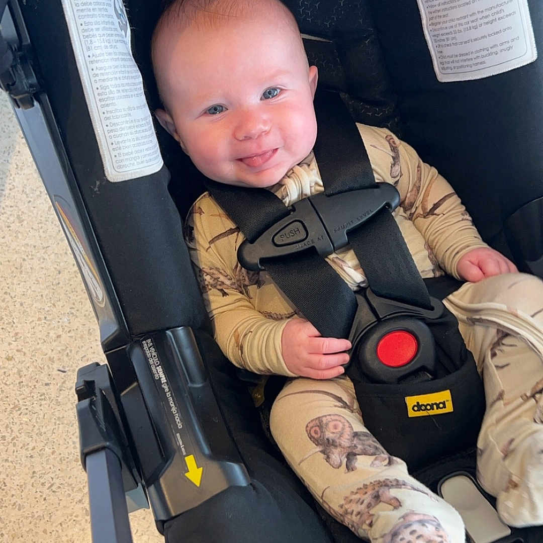 Carson joined the competition — help win amazing prizes! accessories, baby, clothing, coat, face, gun, happy, head, jacket, pants, person, photography, portrait, sleeping, smile, strap, stroller, transportation, vehicle, weapon