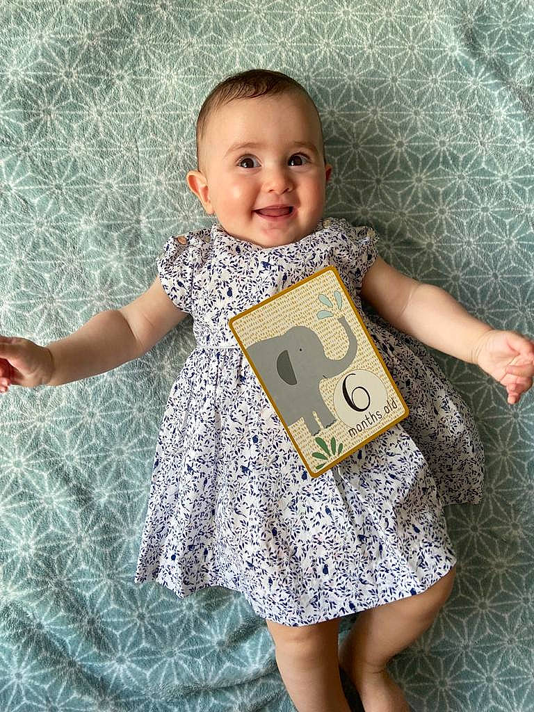 Raphaëlle participe au concours pour gagner de l'argent avec cette photo : adaptation, arm, baby_toddler_clothing, face, facial_expression, fun, gesture, hairstyle, happy, head, joy, linens, pattern, person, sleeve, smile, standing, t_shirt, textile, toddler