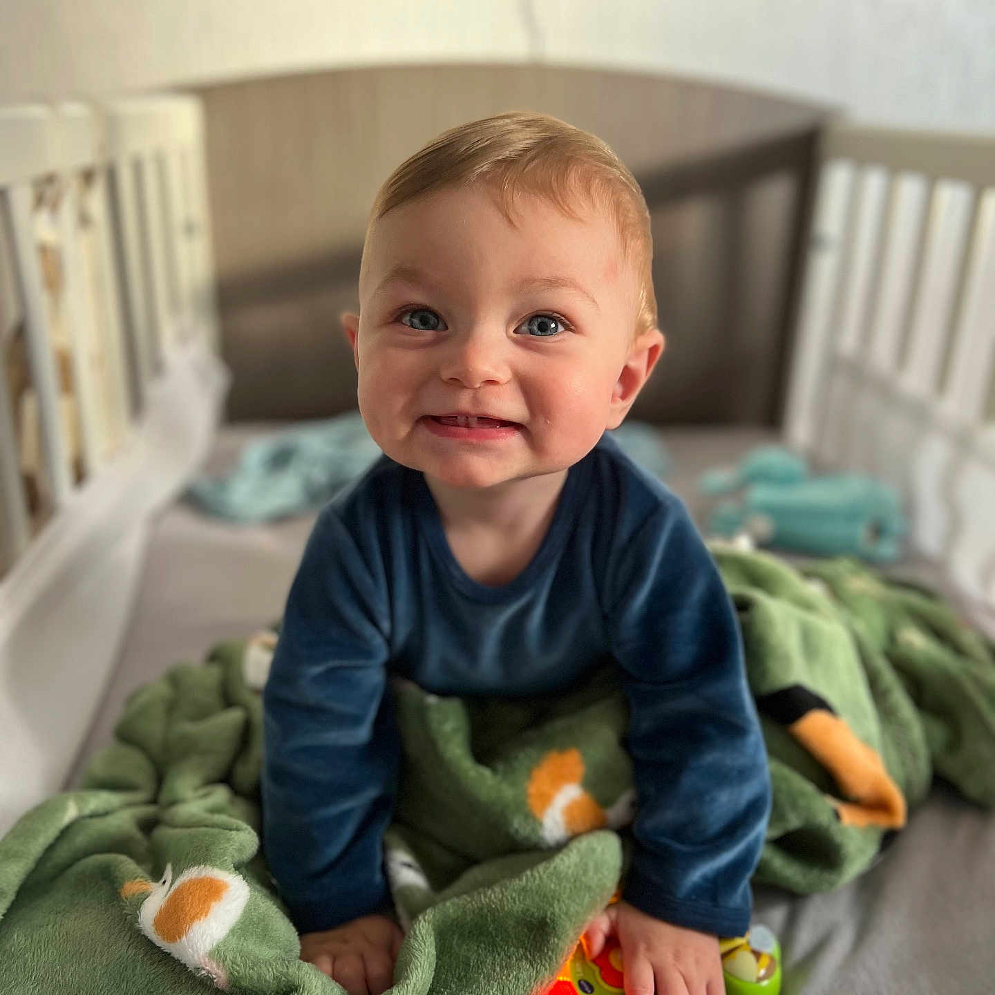 Aaron participe au concours pour gagner de l'argent avec cette photo : baby, blanket, blue_eyes, child, clothing, cozy, crib, cute, face, green, hand, happy, indoor, infant, light, plush, smile, soft, star, toy