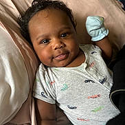 Mason is registered to the contest to win money with this photo: baby, infant, child, onesie, mittens, bed, pillow, blanket, pacifier, cute, smiling, lying_down, indoors, sleepwear, skin, hair, face, tongue_out, closeup, happy