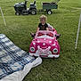 Alice is registered to the contest to win money with this photo: blanket, casual_clothing, child, childrens_toy, curly_hair, cute, daytime, grass, green, lawn_tractor, minnie_mouse, outdoor, park, pink, plaid, playtime, summer, toddler, toy_car, vehicle
