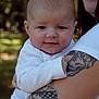 baby, child, infant, person, tattoo, arm, holding, outdoor, nature, portrait, smile, white_clothing, cute, closeup, face, skin, head, happy, adult, love