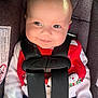 baby, infant, car_seat, smile, red_clothing, snowman, holiday, child, seatbelt, straps, cute, face, portrait, safety, young_child, indoors, happy, clothing, car, infant_clothing