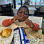 Jerrod is registered to the contest to win money with this photo: accessories, boy, burger, car, chair, child, eating, face, female, food, furniture, girl, head, jewelry, lunch, male, person, ring, transportation, vehicle