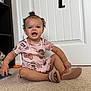 Alaya is registered to the contest to win money with this photo: toddler, child, pink_dress, sitting, carpet, indoor, smiling, sandals, curly_hair, pony_tail, door, shelf, toy, happy, person, floor, young_child, cute, casual, home